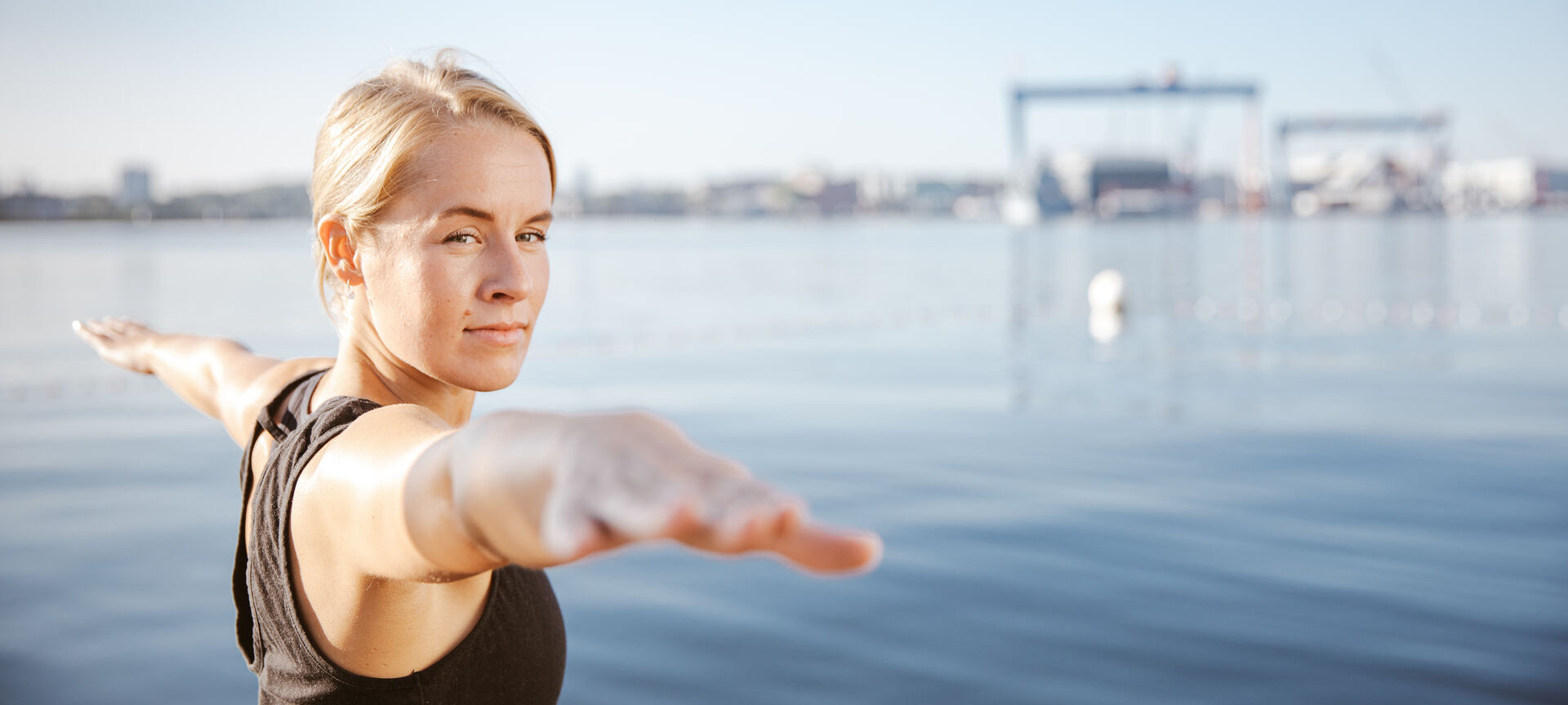Frau macht Yoga an der Förde